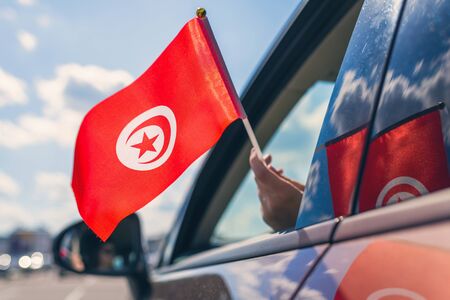 Woman or Girl Holding Tunisia Flag from the open car windowの写真素材