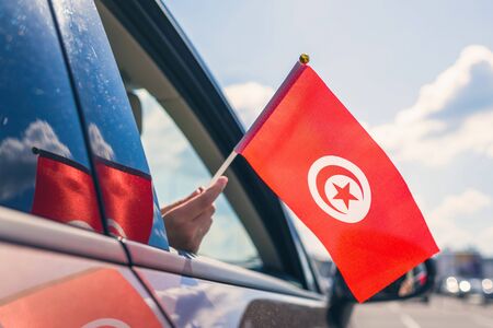 Woman or Girl Holding Tunisia Flag from the open car windowの写真素材