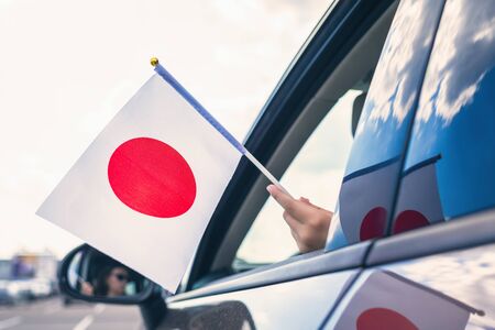 Woman or Girl Holding Japan, Flag from the open car windowの写真素材