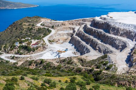 Aerial view of opencast mining quarry with one machinery on the blue sea backgroundの写真素材