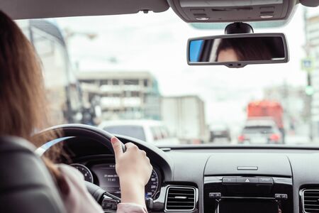 woman is driving on the highway. View from the back seat of the carの写真素材