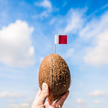 Tropical coconut with Qatar flag in the form of a toothpick in female hands.  Travel concept