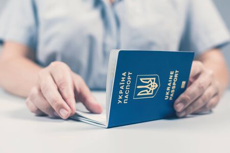 Immigration and passport control at the airport. woman border control officer with Ukrainian passport. Conceptの写真素材