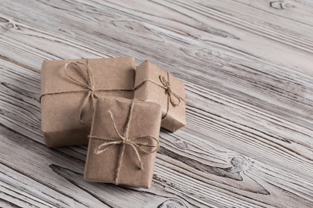 Handmade gifts made from craft paper christmas rope and tree on the rustic wood planks background....