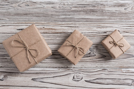 Handmade gifts made from craft paper christmas rope and tree on the rustic wood planks background....