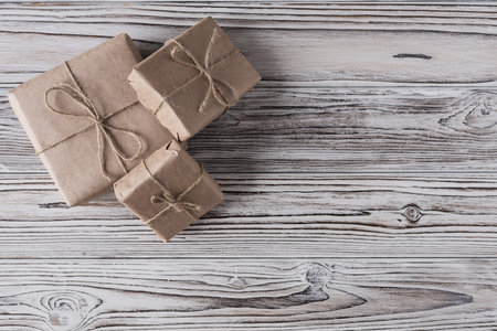 Handmade gifts made from craft paper christmas rope and tree on the rustic wood planks background....