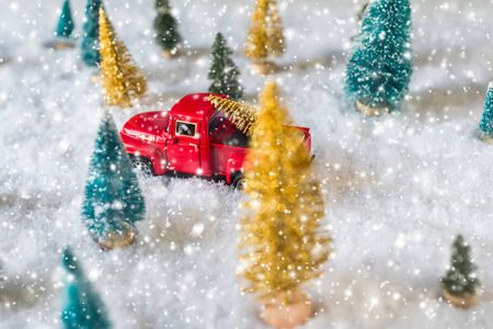 Creative Christmas decoration with red truck and colorful snowy spruces in the snow. Winter forest. Aerial, top view. Flat layの写真素材