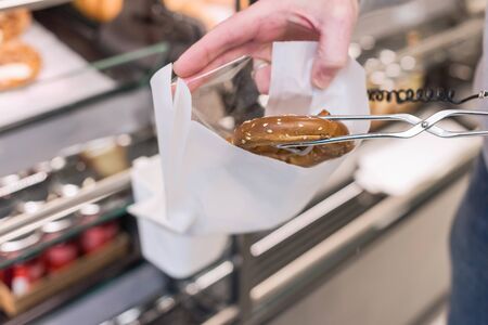 Man buying pretzels in a pastry shop for Christmasの写真素材