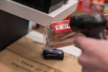 Customer with manual scanner of barcodes scans the scan discount card for buying in supermarket. self cateringの写真素材