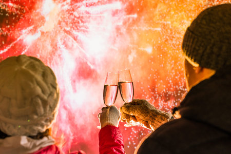 Merry man and woman in the winter clothes toasting with glasses champagne celebrate holiday...