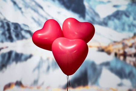 Valentines day.  three reds balloons in form of heart on the snowy mountain background. Beach. Conceptの写真素材
