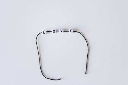 Love word made from letters printing blocks on a black rope. White background
