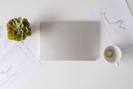 finishing working day with closes laptop with empty drink up cup of coffee in the end of working...