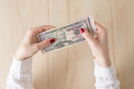 woman hold banknote 50 U.S. dollars in hand and count it. Money exchange. Bank operation. Finance...