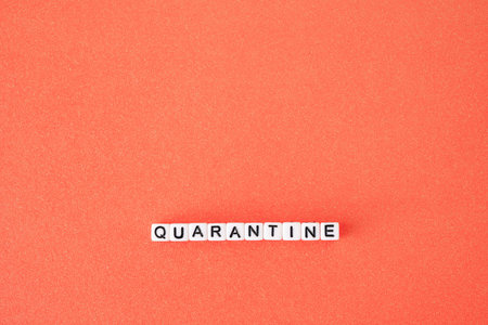 The word quarantine on red background. Worldwide pandemic concept, production and work shutdown