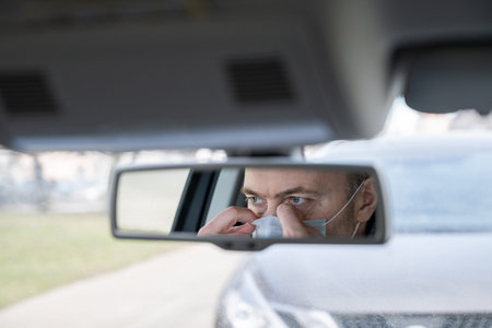 Reflection of face of middle aged man in the medical mask for protect himself from bacteria and...