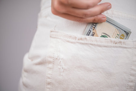 Woman buttocks in a white denim shorts one hundred US dollars in the pocket. concept