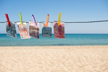 Money of south-east Asia with a clothespin on a rope opposite the sea. Ð¡hina yuan (CNY) Currency,...