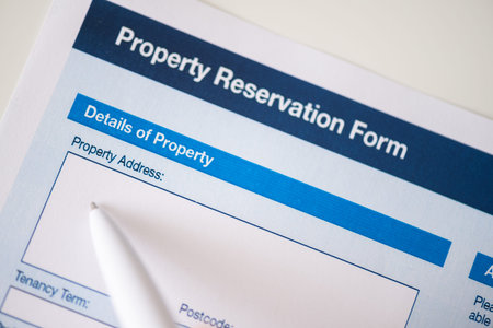 Woman customer filling property reservation form on the table at the office. Rental agreement...