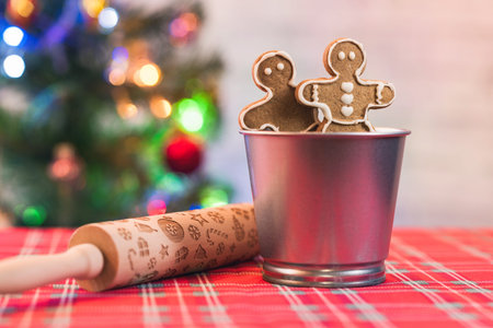 Christmas gingerbread men cookies in an iron bucket, rolling pin on the background of a christmas...