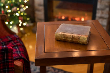 Old retro book on wooden table with christmas tree and fireplace.の写真素材