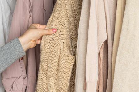 Woman choosing woolen sweater in home cupboard. Season conceptの写真素材