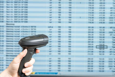 A warehouse woman employee accepts cargo, goods using barcode scanner reading a bar code from and adds to the computer base.の写真素材