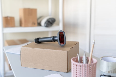 Female owner of start up small business using barcode scanner scanning retail drop shipping package...