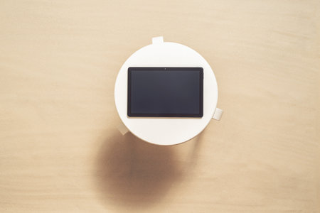 Tablet on the table on the sand of beach under palm trees branch. copy space. Top view. Selected focus computerの写真素材