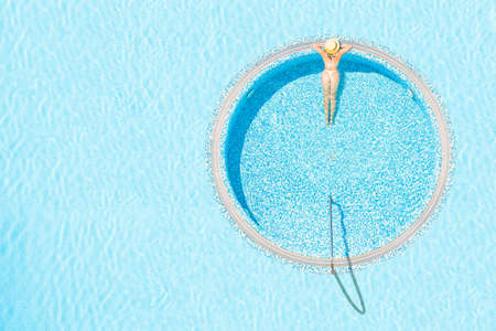 Young alone beautiful sports woman in bikini and hat is swimming . Aerial drone view from above. Tropical summer luxury hotelの写真素材