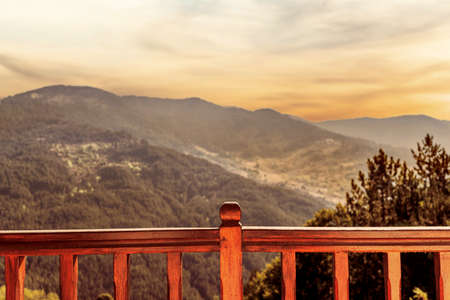 Wooden balcony railing in the mountains at sunsetの写真素材
