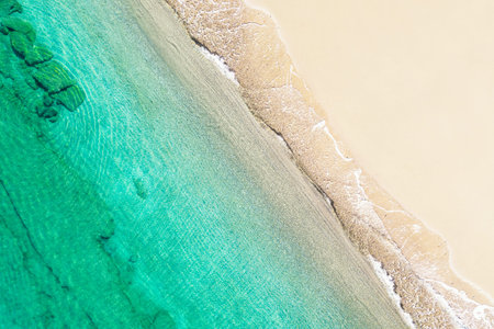 Relaxing aerial beach view with calm sea water and stone, slabs, lump, coral. Summer vacation. Blue...