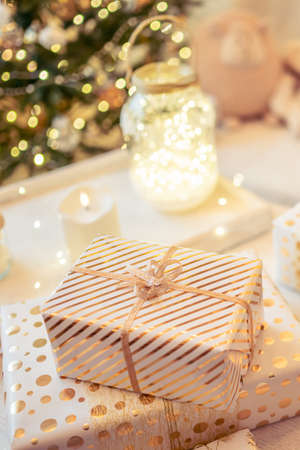 Woman sitting on couch near christmas tree. Female legs, feet in winter woolen socks putting on the table and relaxing after packing handmade gift boxes. Presents for family.の写真素材