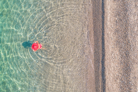 top, aerial view. Young beautiful woman in a red hat and bikini walking, swimming, sunbathe in sea...