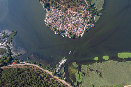 Small island with village, townhomes, forest, boats and yachts in the middle of lake. Drone view, aerial view, top viewの写真素材