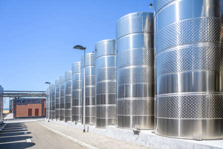Wine steel tanks, equipment of contemporary winemaker factory. Barrels for wine storage. Equipment for the fermentation, distillation of alcohol. Preparation workshop for pure alcohols.の写真素材