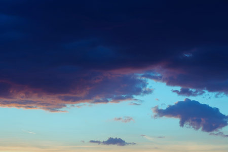 Stormy dramatic sky background with huge blue gray cloud yellow red and orange clouds. Sunset...