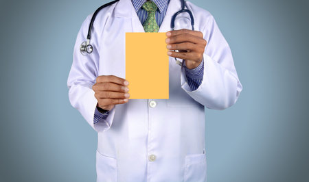Doctor holding card with stethoscope isolated on color backgroun