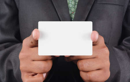 Businessman holding card in black suit isolated on white backgroundの写真素材
