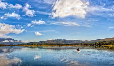Kayaker on a beautiful glacial lake in the mountains on the Kenai peninsula of Alaska during Autumnの写真素材