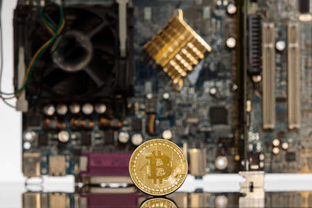 Golden bitcoin in front of a  motherboard dynamically zoomed into the bitcoin concept for crypto currencyの写真素材