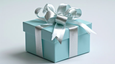 A pastel blue gift box elegantly wrapped with a silver ribbonの素材