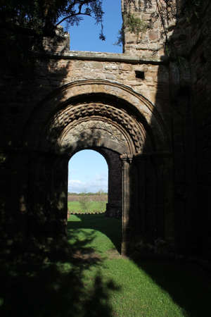 Cistercian Abbey ruins archway in sunlight and shadeの写真素材