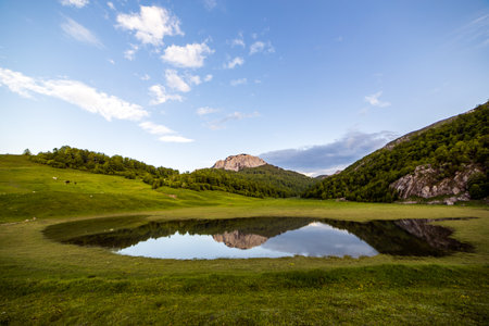 Mountain landscape with lake and blue sky with clouds in the backgroundの写真素材
