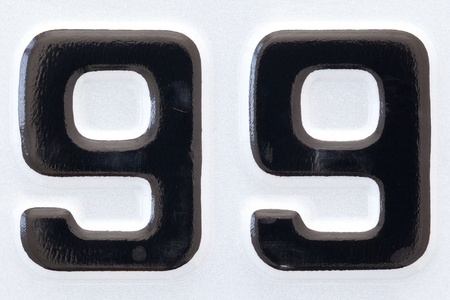 close up shot of new car plate number ninety-nine black lettering on a white backgroundの写真素材