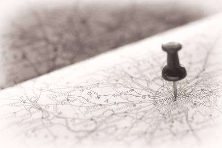 monochrome shot of a pin pointing on the map at London for travel background with shallow depth of field and vignetteの写真素材