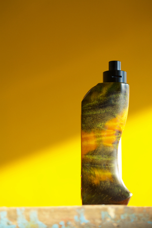 high end yellow green stabilized wood regulated box mods with black rebuildable dripping atomizer on yellow background, vaping device, selective focusの写真素材