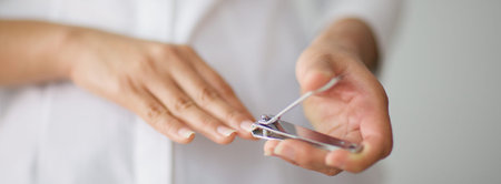 close up shot of a woman cutting her nails for banner background, selective focus