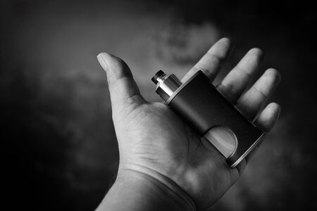 black and white, monochrome shot of high end unregulated bottom feed squonk box mods with rebuildable dripping atomizer in hand, vaping device, selective focusの写真素材