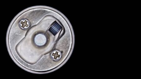 close up, macro shot, top view of single micro coil in high end rebuildable dripping atomizer for flavour chaser isolated on black background, vape gear, selective focusの写真素材